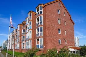un edificio de ladrillo rojo con bandera americana en Haus Horizont I HZ04, en Sahlenburg