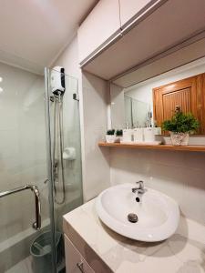 a bathroom with a sink and a shower and a mirror at Relaxing Escape with Spacious Sofa Corner in Mandurriao