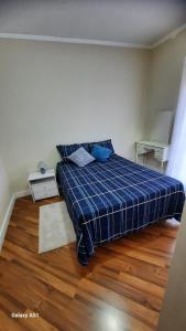 a bedroom with a bed with a blue plaid blanket at ZL Brasil in São Paulo