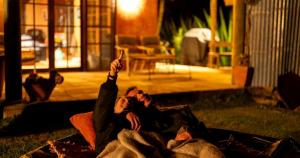 a couple laying on the grass with their hands in the air at Pueblo at Indigal - Relax Rejuvenate Reconnect in Charlotte Bay