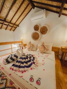 a bedroom with a bed with flowers on it at RATU Village - Luxury Island Apartment & Private Villa Gili Air in Gili Islands
