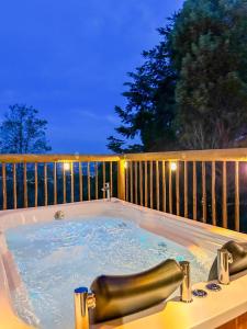 リオネグロにあるRomantic Glamping Cabin with Jacuzzi & Viewsの- 夜間のデッキにジャグジータブ