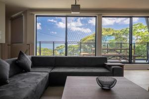 a living room with a couch and a large window at SANA伊豆大室山 -Pool Villa- in Ito