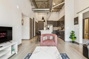 an open kitchen and living room with a pink chair at CozySuites PHX RORO Gym Pool Pets & Parking #15 in Phoenix