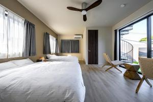 a bedroom with a large bed and a ceiling fan at SANA伊豆大室山 -Pool Villa- in Ito