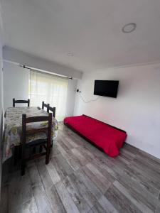 Un dormitorio con una cama y un televisor de pantalla plana. en Departamento en Claromeco, en Balneario Claromecó