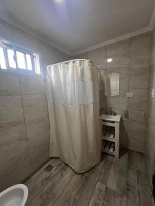 Un baño con ducha, inodoro y lavabo. en Departamento en Claromeco, en Balneario Claromecó
