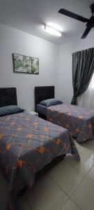 a bedroom with two beds and a ceiling fan at TRAVELLERS' ROOM JrMaster Near KLiA SiC at UmahSinggah NamTiga in Sepang
