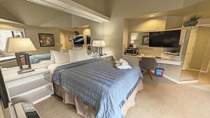 a bedroom with a bed and a desk and a television at River Ridge 423B condo in Bend