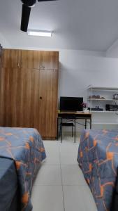 セパンにあるTRAVELLERS' ROOM JrMaster Near KLiA SiC at UmahSinggah NamTigaのベッドルーム1室(ベッド2台、木製キャビネット付)