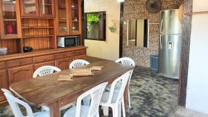 a kitchen with a table and white chairs and a refrigerator at Casa Bem-Te-Vi | Alter do Chão in Alter do Chao