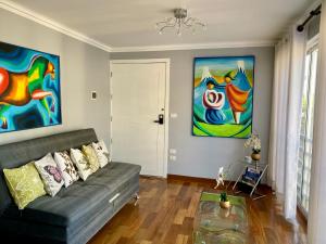 科恰班巴Exclusivo Departamento en Edificio Alessandria的客厅里有一张沙发，墙上挂着画