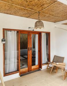 a living room with wooden doors and a chair at RATU Village - Luxury Island Apartment & Private Villa Gili Air in Gili Islands +28 photos