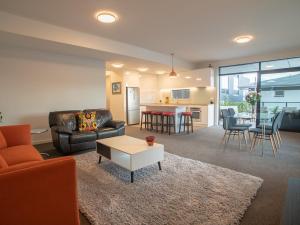 a living room with a couch and a table at Riverwalk Apartments - 3 Bedrooms in Nelson