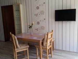 a wooden table with chairs and a vase with flowers on it at One-bedroom apartment in Möttau