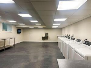 una grande stanza con una fila di lavandini di 416 Modern Brand New Studio Apartment a East Spotswood Altre 6 foto