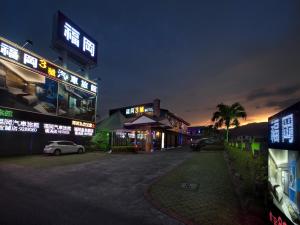 un groupe de bâtiments avec des panneaux de néons la nuit dans l'établissement Fukun No. 3 Motel, à Yilan