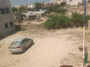 a car parked in a dirt lot next to a building at DWARKA HOME STAY AC rooms Hall For family only in Dwarka