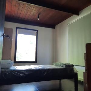 a room with a bed and a window at Casa quinta con jardín y pileta in Luján