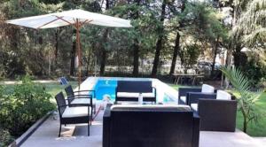 a patio with chairs and an umbrella next to a pool at Casa quinta con jardín y pileta in Luján