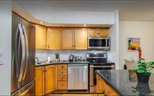 a kitchen with wooden cabinets and a stainless steel refrigerator at The Jazz Room in Toronto