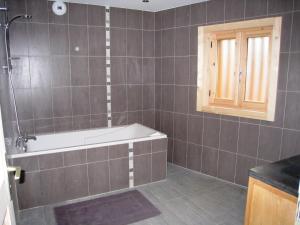 un bagno con vasca e finestra di Chalet confortable à Samoëns, 10 pers, 4 chambres, WIFI, parking - FR-1-815-47 a Samoëns Altre 5 foto