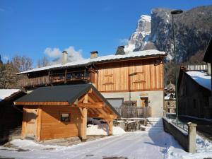 un grande edificio in legno nella neve con una montagna di Chalet confortable à Samoëns, 10 pers, 4 chambres, WIFI, parking - FR-1-815-47 a Samoëns