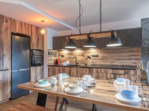 a kitchen with a wooden table with dishes on it at Appartement moderne, Alpe d'Huez, 6 pers, cosy et pratique - FR-1-645-87 in L'Alpe-d'Huez