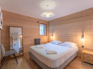 a bedroom with a large white bed and a chair at Appartement moderne, Alpe d'Huez, 6 pers, cosy et pratique - FR-1-645-87 in L'Alpe-d'Huez