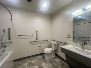 a bathroom with a toilet and a sink and a mirror at 403 Modern Brand New Studio Apartment in East Spotswood