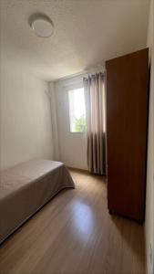a bedroom with a bed and a window at Conquista Salvador in Salvador