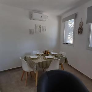a dining room with a table and white chairs at Departamento moderno a estrenar Santo Tomé, Santa Fe in Santo Tomé