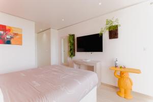 a bedroom with a bed and a tv on a wall at Sunset Room in Chambort