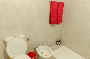 baño con aseo blanco y toalla roja en Punto panorámico, piso 22 con cochera, en Santa Fe