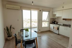 Una cocina y un comedor con una mesa de cristal. en Punto panorámico, piso 22 con cochera, en Santa Fe 6 fotos más