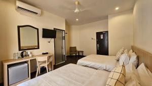 Una habitación de hotel con dos camas, un escritorio y un espejo. en Hotel 22 Gurney, Penang, en George Town