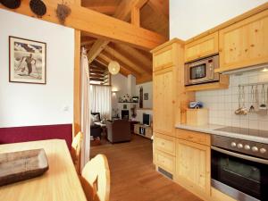 cocina con armarios de madera y mesa de comedor en Chalet in Königsleiten near Ski Lift, en Wald im Pinzgau