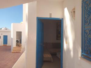 una porta blu aperta in una stanza con una panca di Jamila1 a Taguermess Altre 6 foto