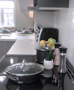 a kitchen with a stove with a pan on the counter at Stylish 2bed, 2bth Apt Malls & 25 Mins To Toronto in Mississauga