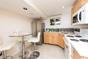 a kitchen with white appliances and a table and chairs at 4 Bedroom Semi-basement Suite in Burnaby Metrotown in Burnaby