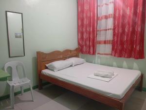 a small bedroom with a bed and a chair at Evashore Beach Resort in Limasawa Island