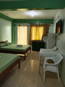 a room with two beds and a table and a chair at Evashore Beach Resort in Limasawa Island