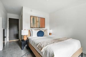 a white bedroom with a large bed and a painting at Adelynn Studio Walkable Kerns Spanish Charm in Portland