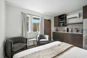 a bedroom with a bed and two chairs and a kitchen at Adelynn Studio Walkable Kerns Spanish Charm in Portland +19 photos
