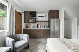 a kitchen with a refrigerator and a chair in a room at Adelynn Studio Walkable Kerns Spanish Charm in Portland