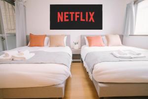 two beds in a room with a netflix sign above them at リトリートコート薬院 in Fukuoka