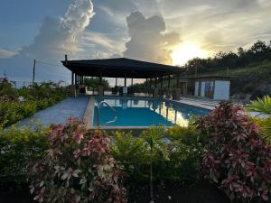 a swimming pool with a gazebo and the sunset at Jepel's Escape in Florence Hall