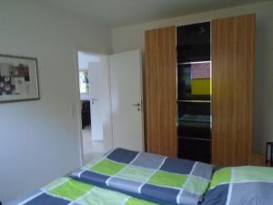 a bedroom with a bed and an open closet at Ferienwohnung Hilbers in Horumersiel