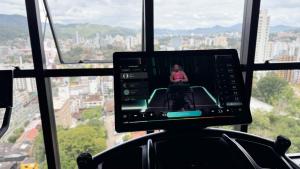 a person in a room with a view of a city at ASA | Loft UP ao Lado da FURB | Piscina + Oktober in Blumenau