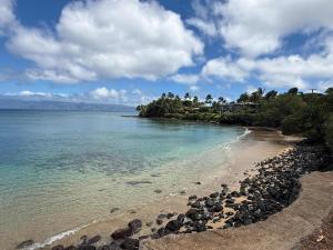 a beach with rocks and the ocean on a cloudy day at Beachfront B&B w Free Breakfast, AC & Sunset View in Lahaina